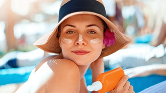 donna con cappello con crema sulle guance